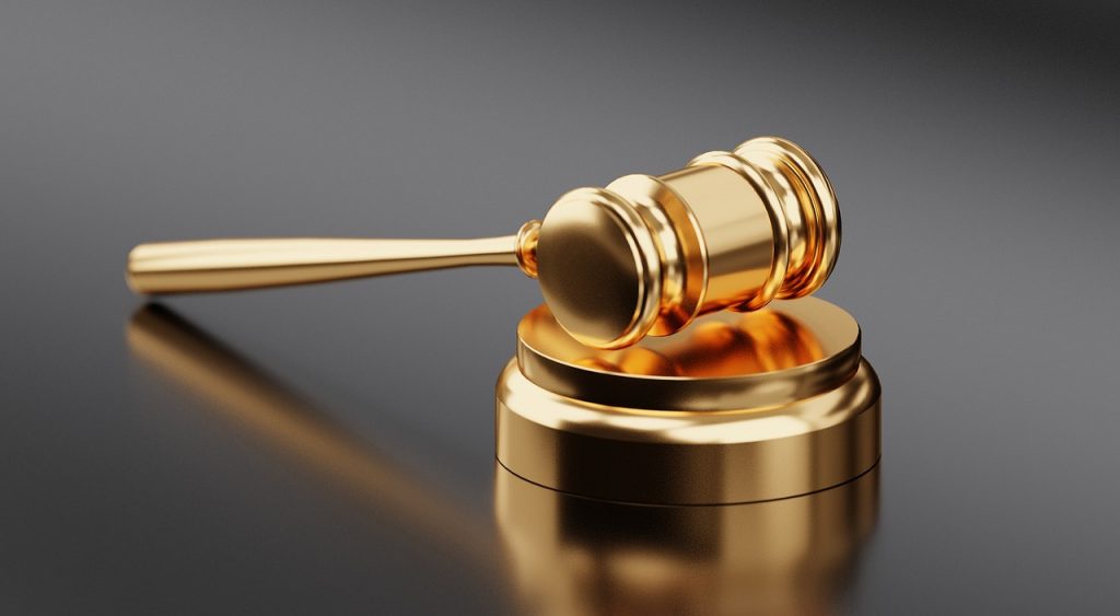 A golden gavel rests on a matching golden sound block against a smooth, dark background, symbolizing law, justice, or legal proceedings. The polished finish highlights their metallic appearance, reminding us of the potential pitfalls in personal injury cases.